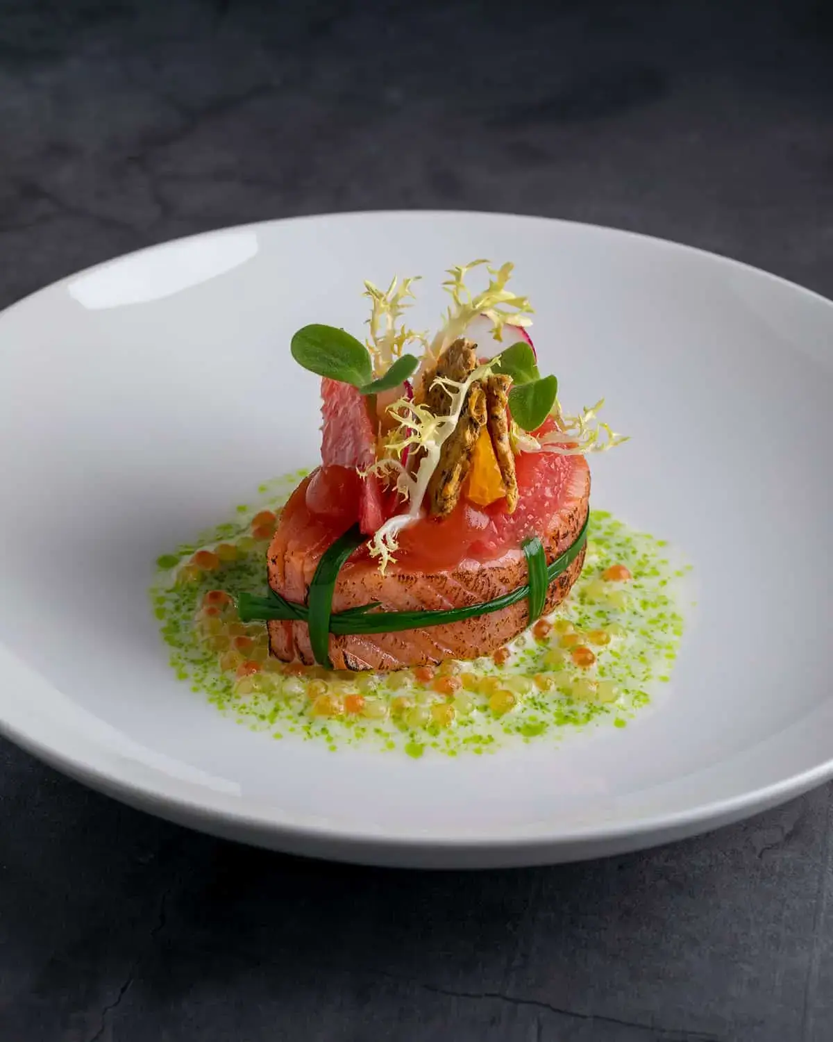 Ein Lachs Sashimi ist auf einem Teller angerichtet im Gourmetrestaurant Hanse Stube in Köln